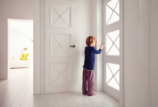 young boy opens the door at home - snooper imagens e fotografias de stock