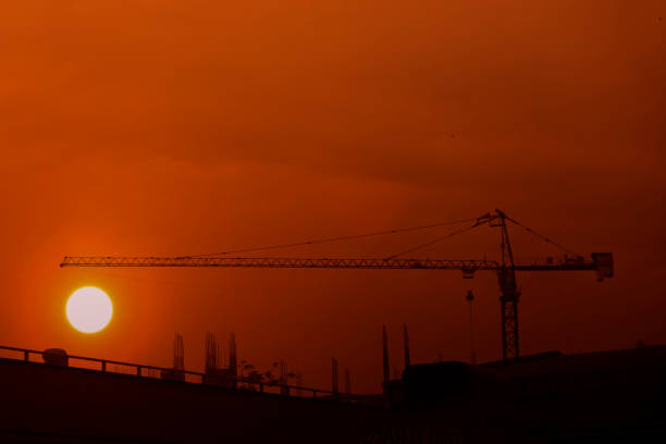 istock tower crane with the sun background 924276328