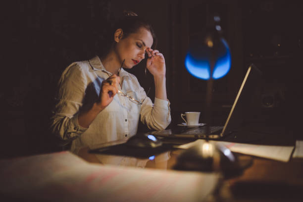 istock Exhausted woman using laptop and working late 924284578