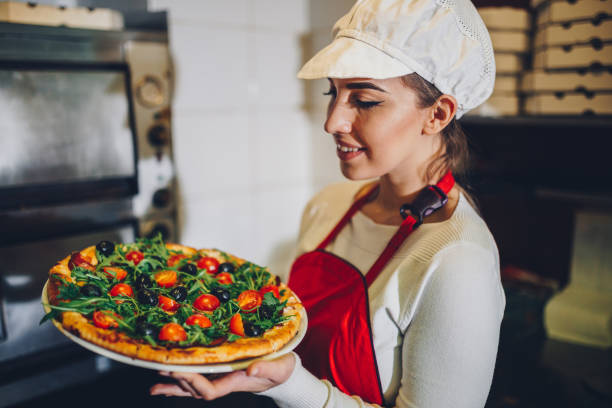 istock Woman working in the restaurant making pizza 924285234