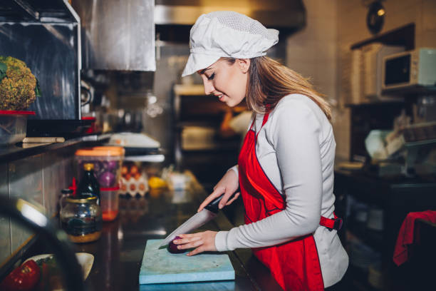 istock Woman making meal with an onion in the restaurant kitchen 924285320