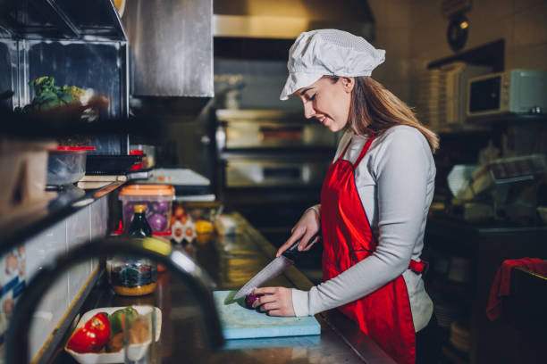 istock Woman making meal with an onion in the restaurant kitchen 924285366