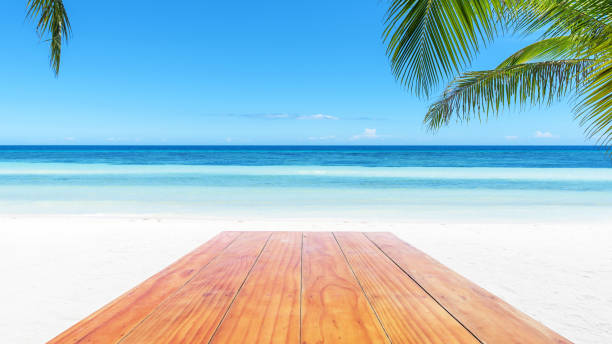 istock Empty wooden table beside tropical paradise beach 924290784