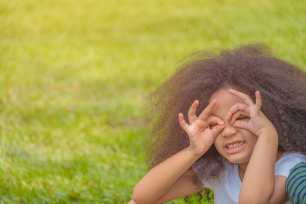 istock Girl kid smile with use her hand on her eye to looking some thing 924290796