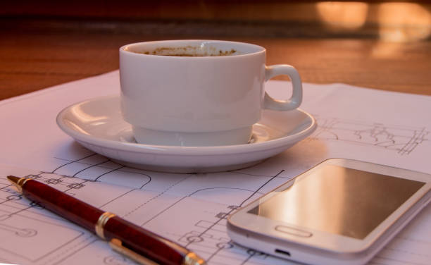 istock Cup of coffee, cellphone, the project, drawing, pen on desktop selective focus 924294220