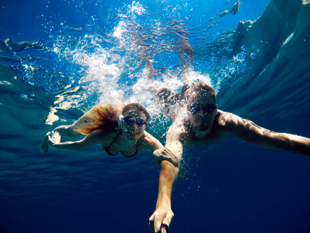 istock Cheerful couple having fun underwater and making selfie. 924294230