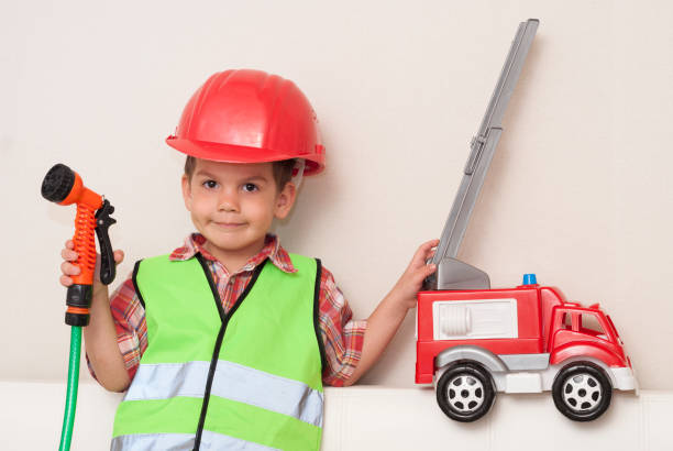 istock child in a red helmet and with a fire engine 924308156