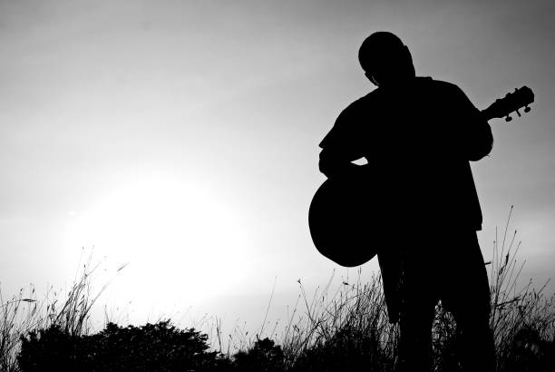 istock Abstract beautiful man playing Guitar in the foreground on clear sky background. 924312610