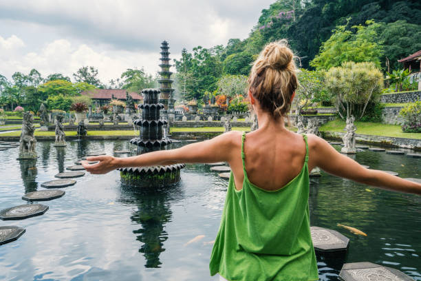 Young woman embracing Tirta Gangga temple, Bali, Indonesia stock photo