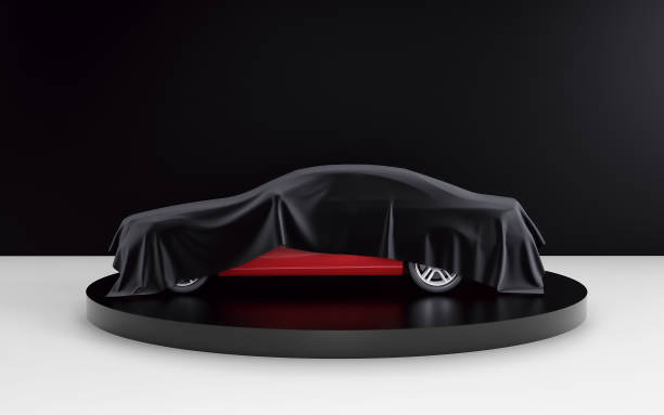 istock New red car hidden under black cover on black and white background. 3d render 924325636