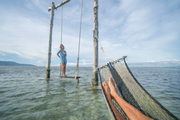 istock Playing couple by the beach, swing and hammock relaxation time 924326162
