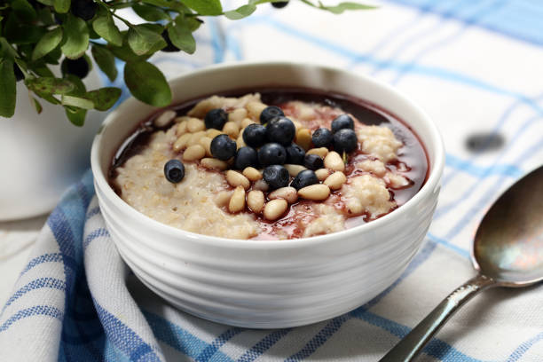 Oatmeal porridge with forest blueberry and pine nuts