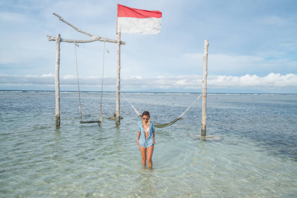 Girl walking on the beach, swing by the sea, Indonesia Young woman walking by the sea, beautiful and idyllic landscape. People travel vacations concept. gili trawangan stock pictures, royalty-free photos & images