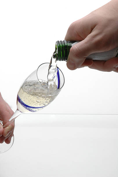 Liquid being poured into wine glass stock photo