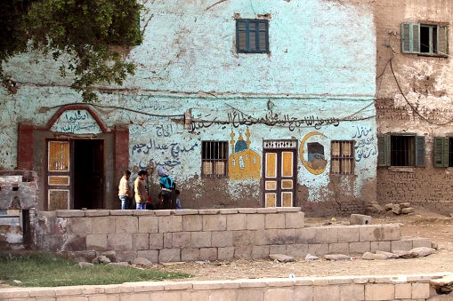 Aswan-Luxor, February 2018: Village at the riverbank of Nile river. A decorated house in Egypt signals its owner has completed the haj pilgrimage to Mecca.
