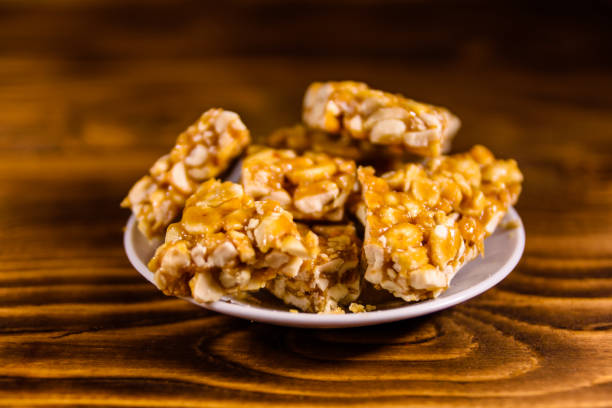 istock Ceramic plate with peanut brittles on wooden table. 924348056