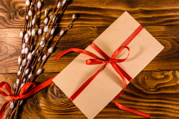 istock Pussywillow bouquet and cardboard gift box on a wooden table. Top view 924348110