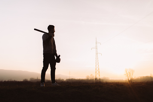 Silhouette portrait of a determined baseball player, practicing at sunset