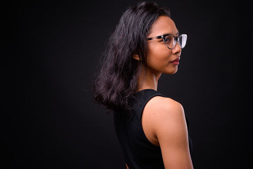 Portrait Of Young Asian Woman Against Black Background