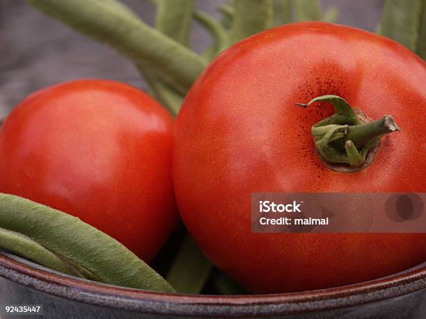 Un Pomodoro Due Tomatoes E Freschi Chicchi Di Ritiro - Fotografie stock e altre immagini di Agricoltura