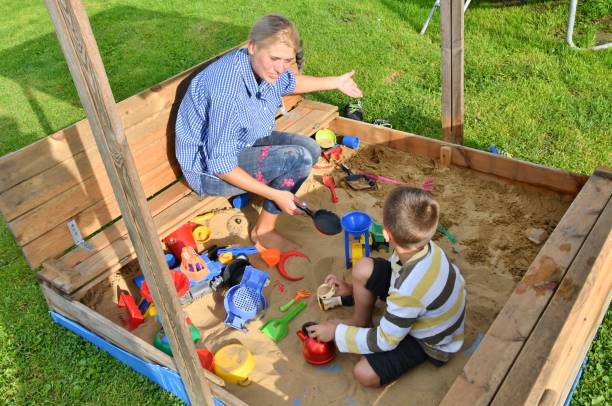 familie kind junge mutter spielen im sandkasten im sommer - sandbox child human hand sand stock-fotos und bilder