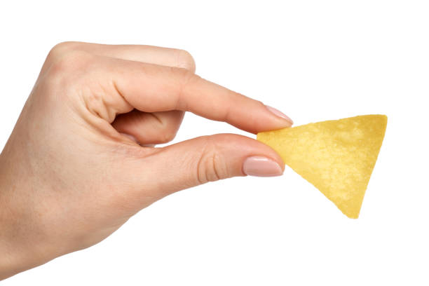 istock Corn chips, triangle nachos in hand. Isolated on white background. Fast food snack, mexiacan tortilla 924357096