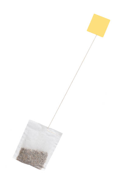 Tea in paper bag with yellow label. Isolated on white background. Herbal teabag.