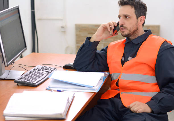 ingegnere che lavora con i progetti alla scrivania - telephone network control room foto e immagini stock