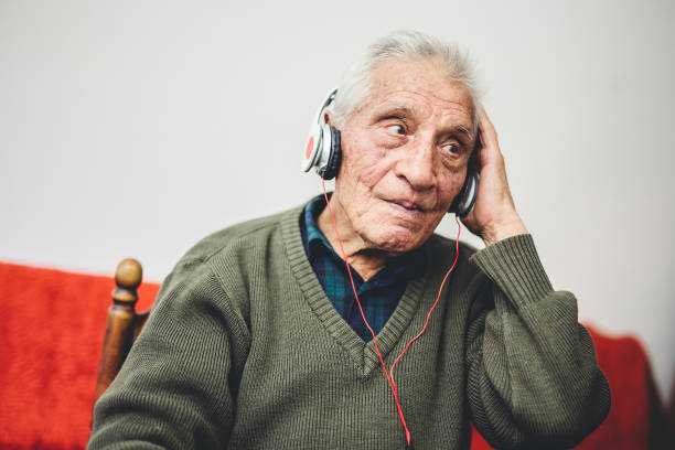 Enjoying The Groove An old man in his 80s listening to his music on a new headset old person listening to radio stock pictures, royalty-free photos & images