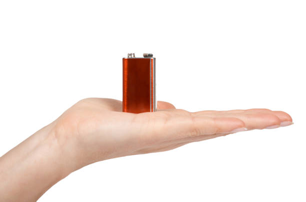 istock 9V battery, nine volt power cell in hand. Isolated on white background 924360562