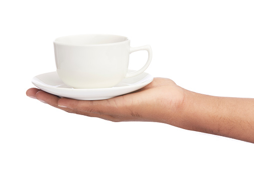 hand with white cup and saucer isolated on white.