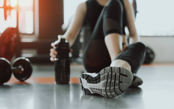 entrenamiento de ejercicio de mujer en la última hora de fitness gimnasio relajarse holding proteína agitar la botella después de deporte de entrenamiento con pesas y fisicoculturismo estilo de vida saludable. - aerobics beautiful bottle body fotografías e imágenes de stock