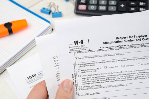 istock Man holding US tax form W-9 924372568