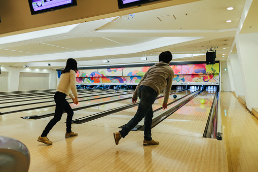 A Japanese couple is playing bowling.
