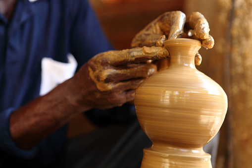 Hands of a potter making pot.