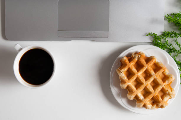 istock Notebook with hot coffee with wafer on wood table 924381650