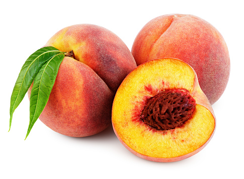 Group of peaches with half and green leaves isolated on white background with clipping path