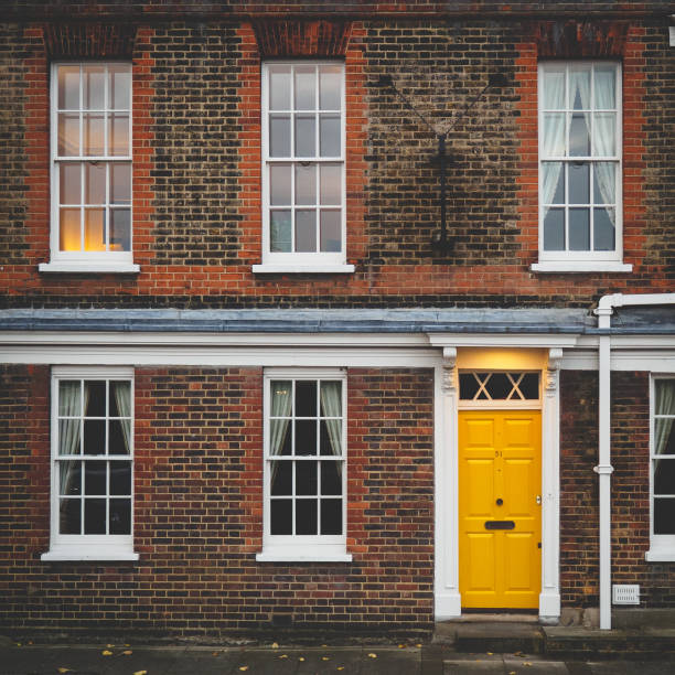 London, UK - February, 2018. A typical Georgian house with a yellow door on central London. Square format.