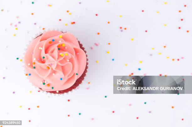 Cupcake Red Velvet With Blue And Pink Whipped Cream Decorated With Colorful Sprinkles Stock Photo - Download Image Now