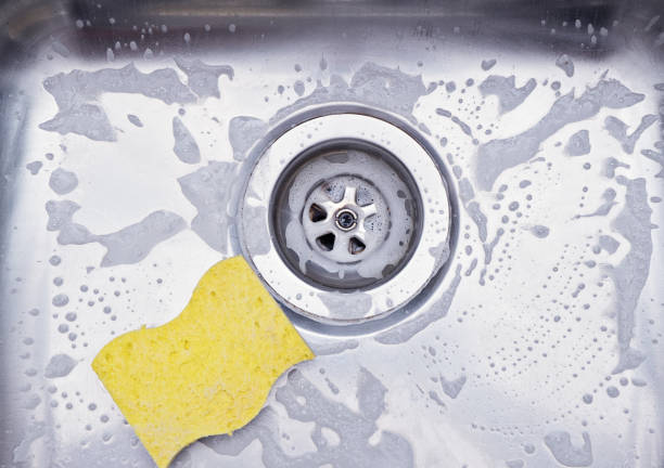 Close up sink drain and yellow sponge Close up sink drain and yellow sponge. Cleaning metallic sink housework concept porous sponge stock pictures, royalty-free photos & images