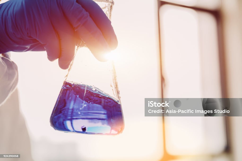 Flask in scientist hand. Crude Oil, Equipment, Fossil Fuel, Human Hand, Liquid, Man Chemical Stock Photo