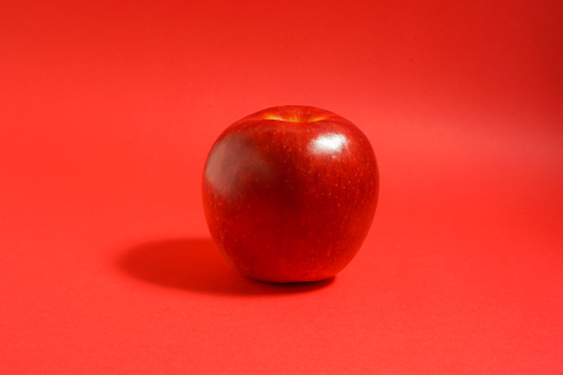 red apple, red background