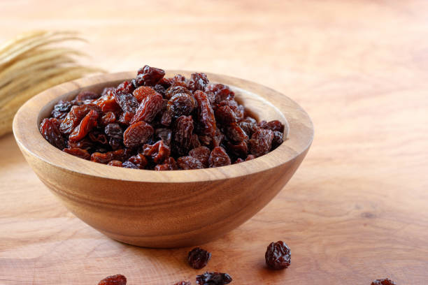 Raisin in bowl on wooden background. Raisin in bowl on wooden background. raisin stock pictures, royalty-free photos & images