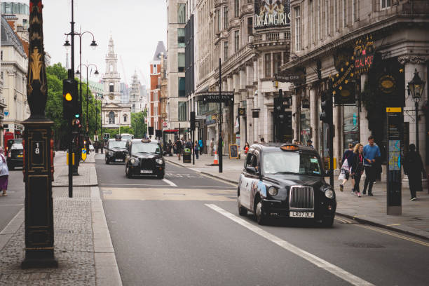 typical black cabs on the strand, london. - strand imagens e fotografias de stock