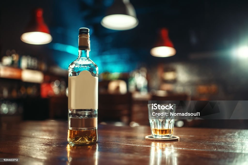 アルコールとバーのカウンターのクローズ アップにガラスのボトル - ウイスキーのロイヤリティフリーストックフォト