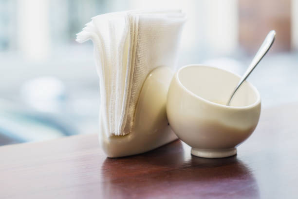 Sugar bowl with spoon and napkin holders on the table in a cafe.