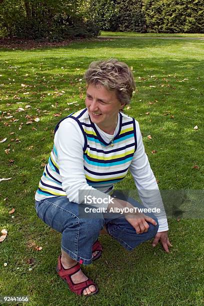 Frau Im Park Stockfoto und mehr Bilder von 40-44 Jahre - 40-44 Jahre, Attraktive Frau, Blumenbeet