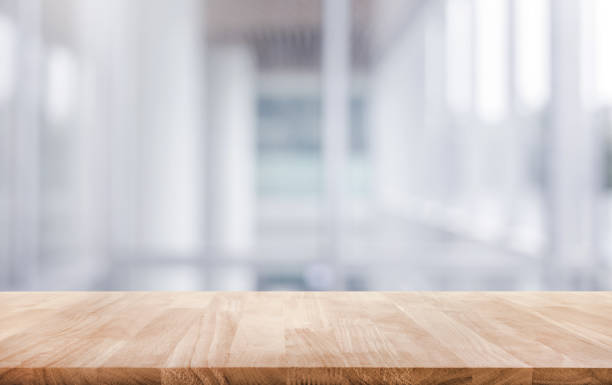 Wood table top on white abstract background form office building.