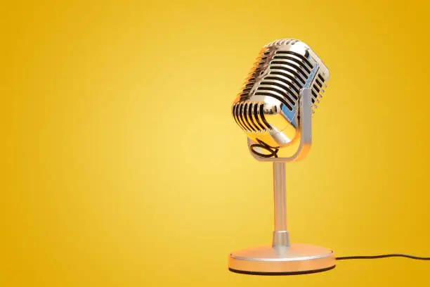 Retro vintage microphone on yellow background studio.