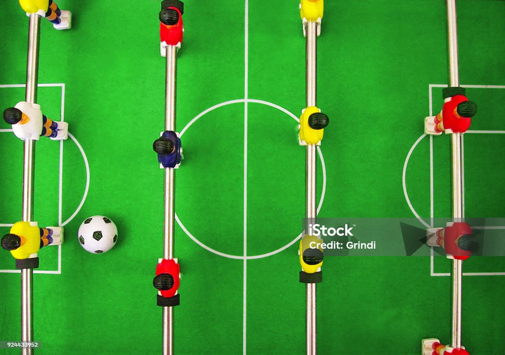 Football soccer table game. Team building play Football soccer World Cup banner. Yellow, red and blue players on metal rods are on green field lawn with big ball. Sport game and recreations for kids and adults Foosball Stock Photo